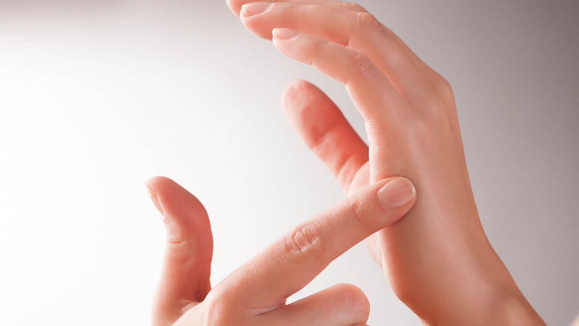 a finger presses a pressure point on the opposite hand