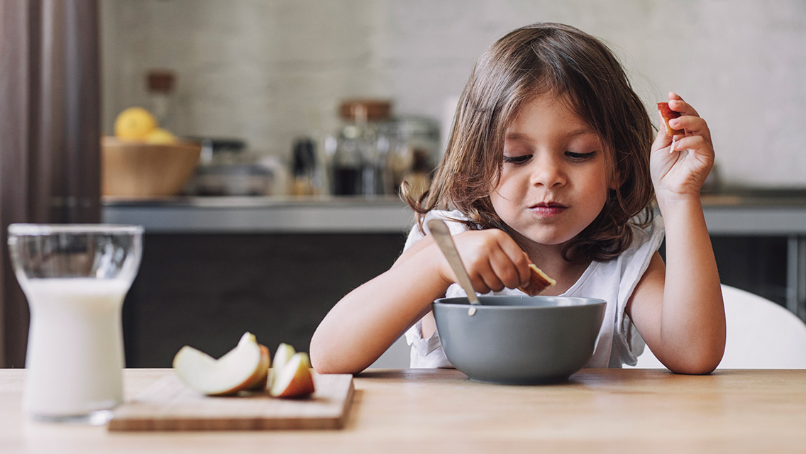 a young child eats a healthy snack.