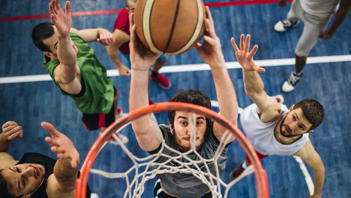 adults playing basketball