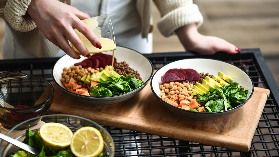person preparing healthy salad bowls