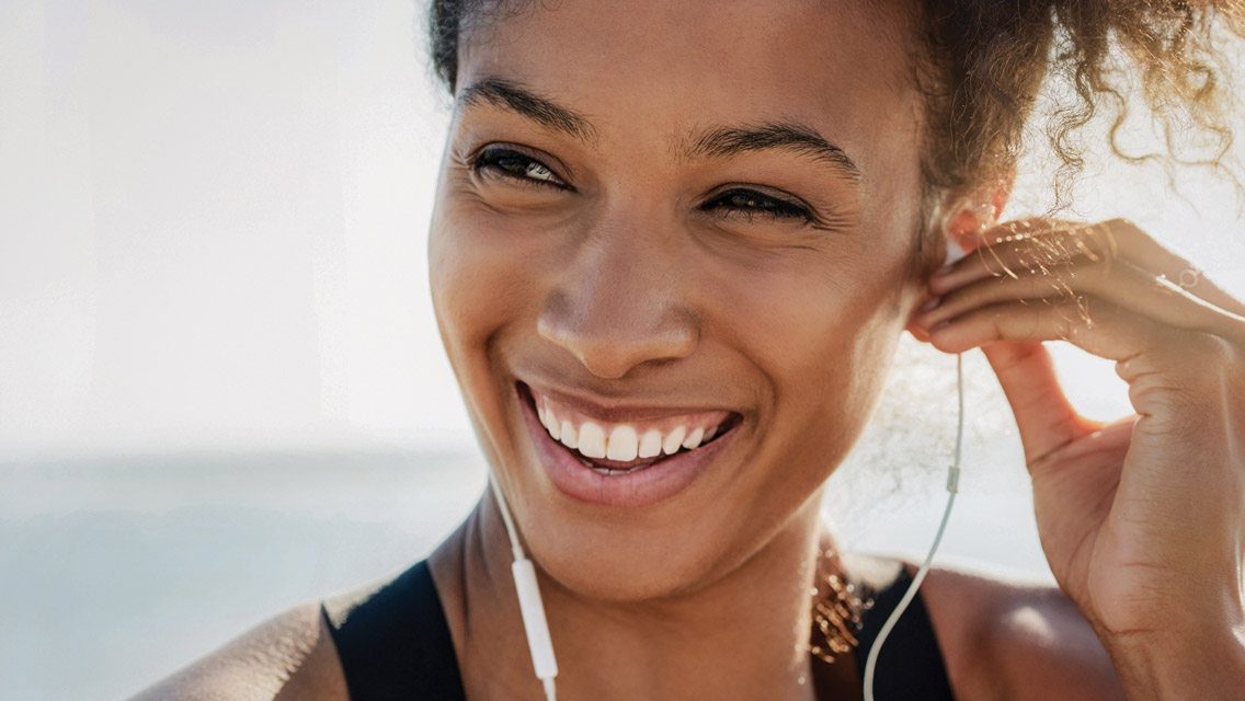 a woman smiles with earphones