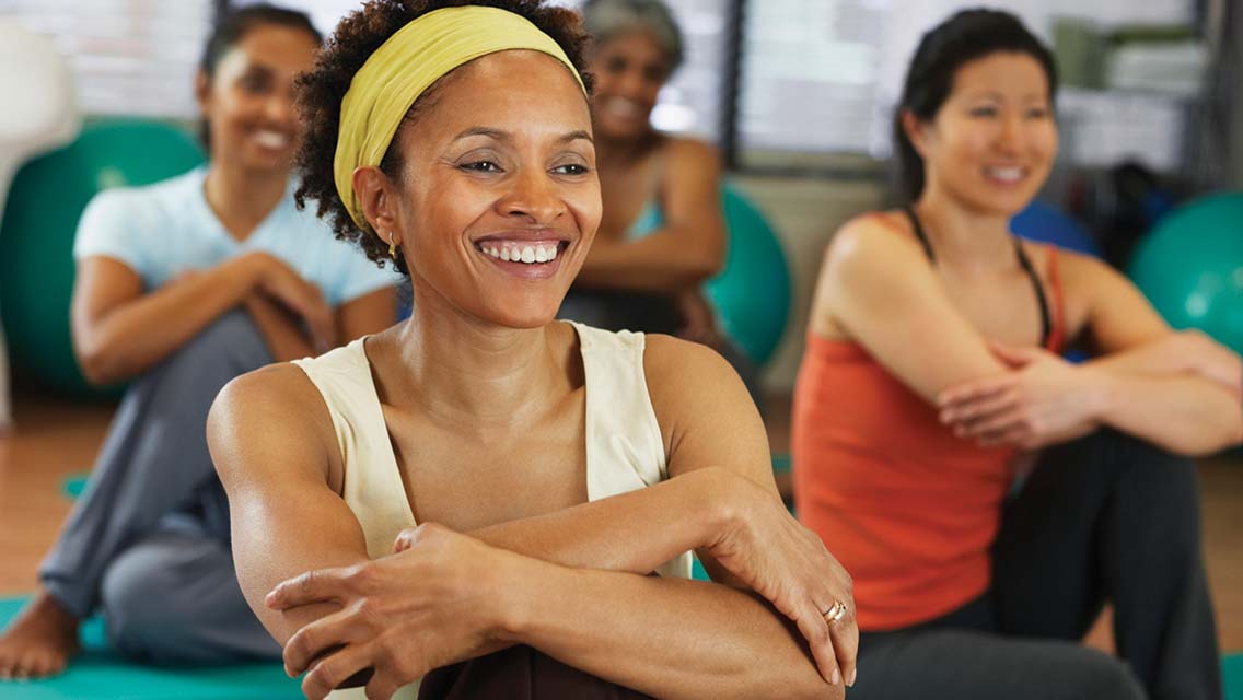 a woman smiles during a group fitness class