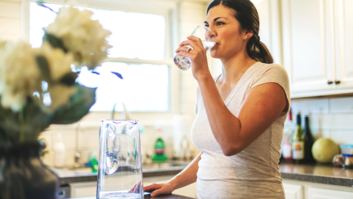 a woman drinks a glass of water