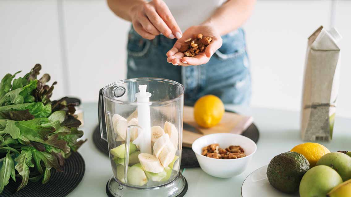 a person prepares a whole foods smoothie.