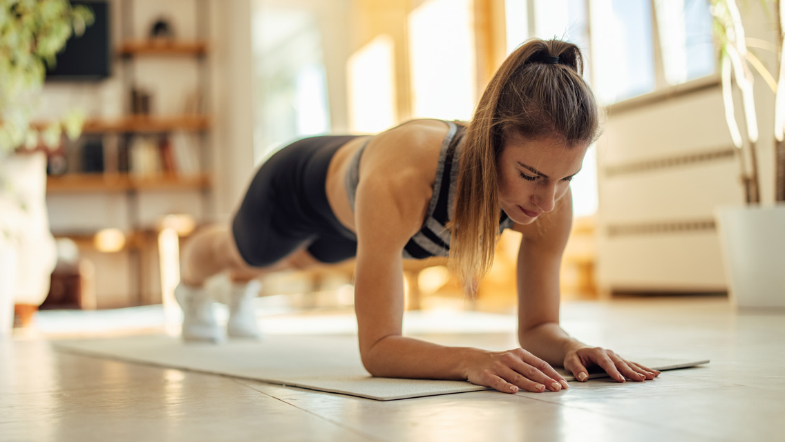 a woman holds forearm plank