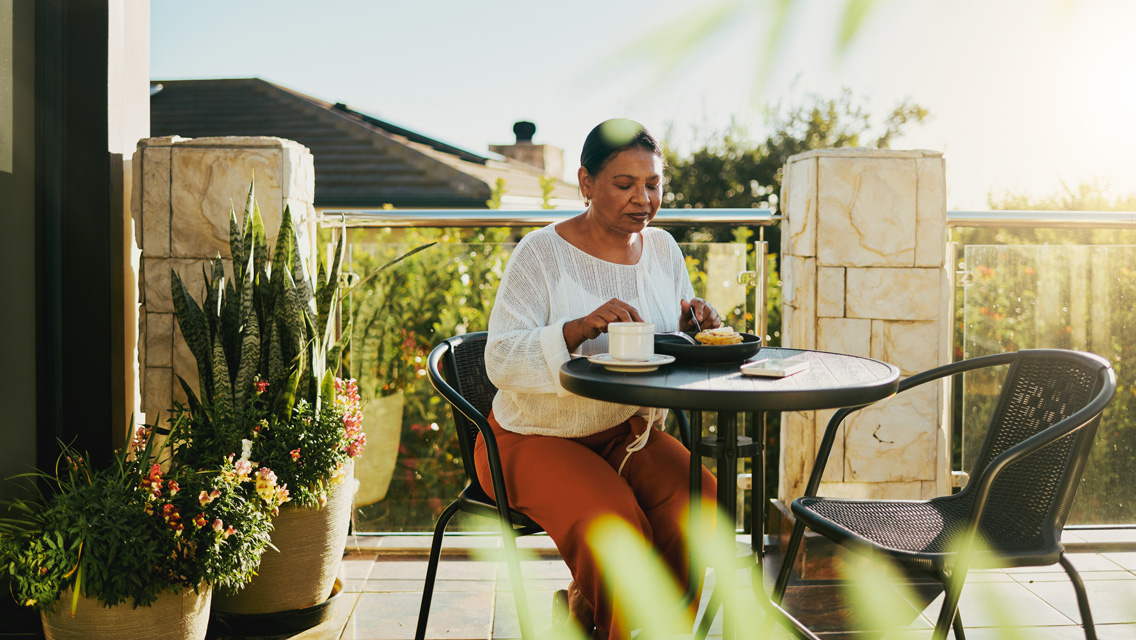 a woman enjoys a meal on her patio