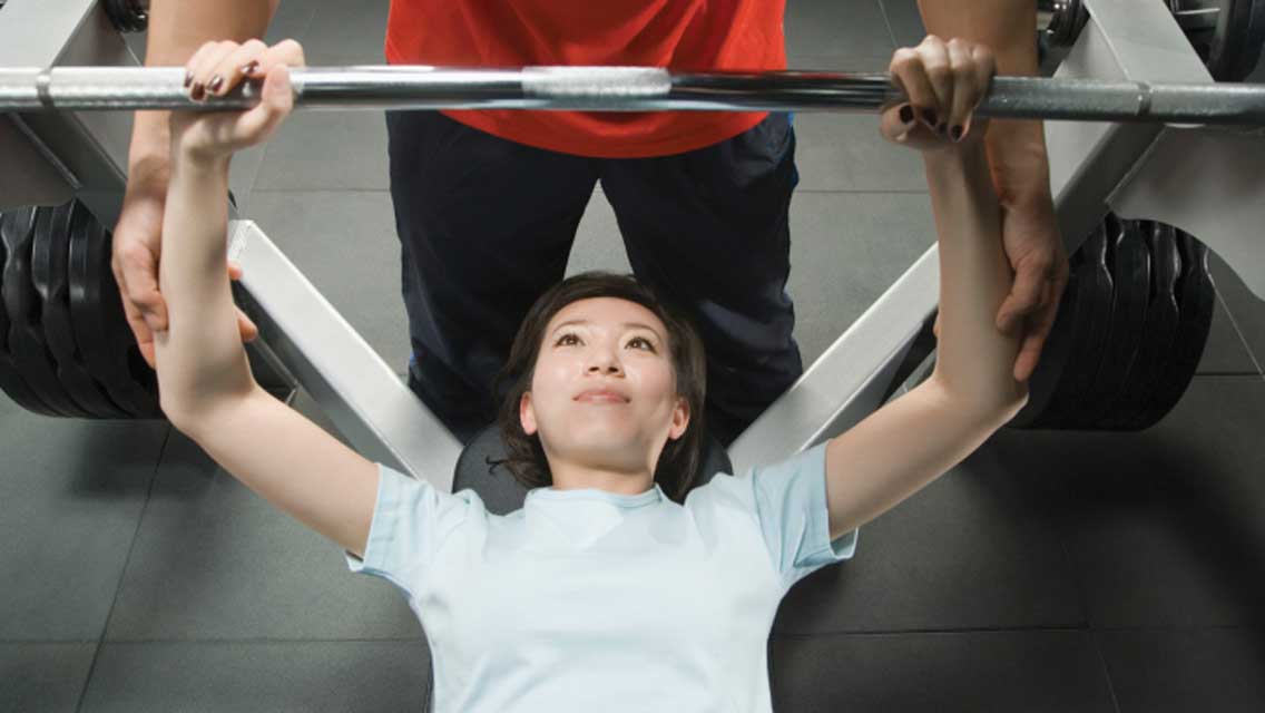 a woman performs a chest press