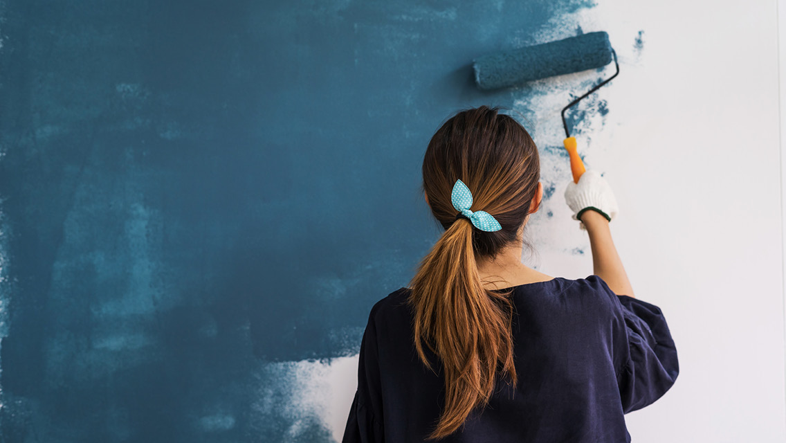 a woman paints a wall
