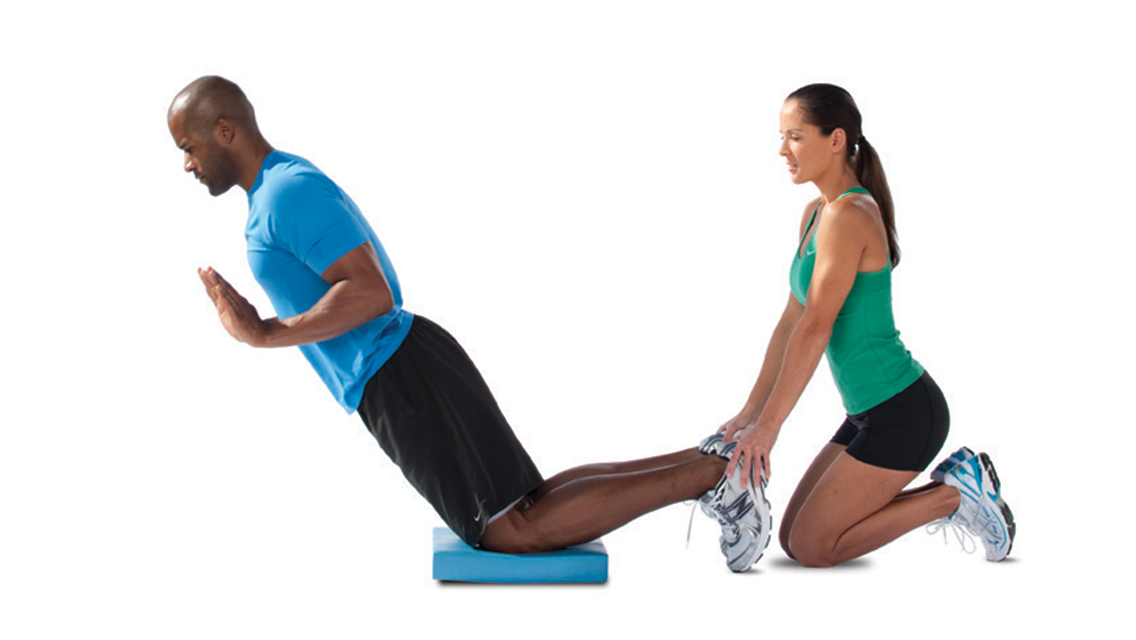 workout partners perform the glute-ham exercise