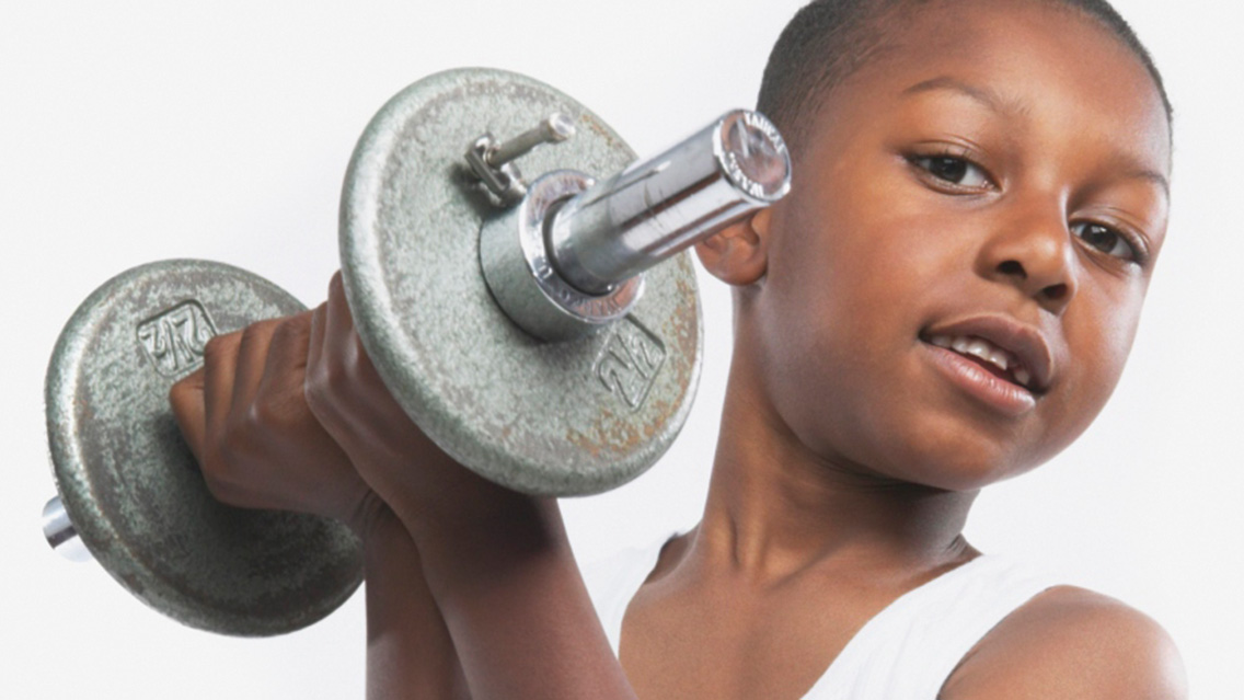 a young boy lifts weights