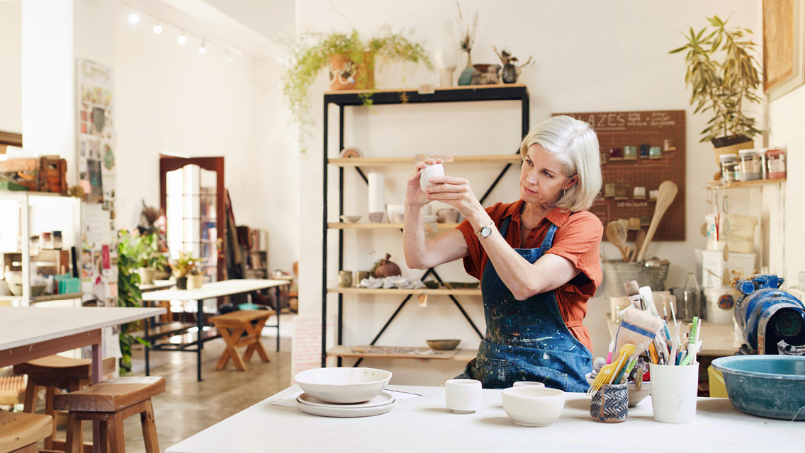 a woman looks a pottery in an art studio