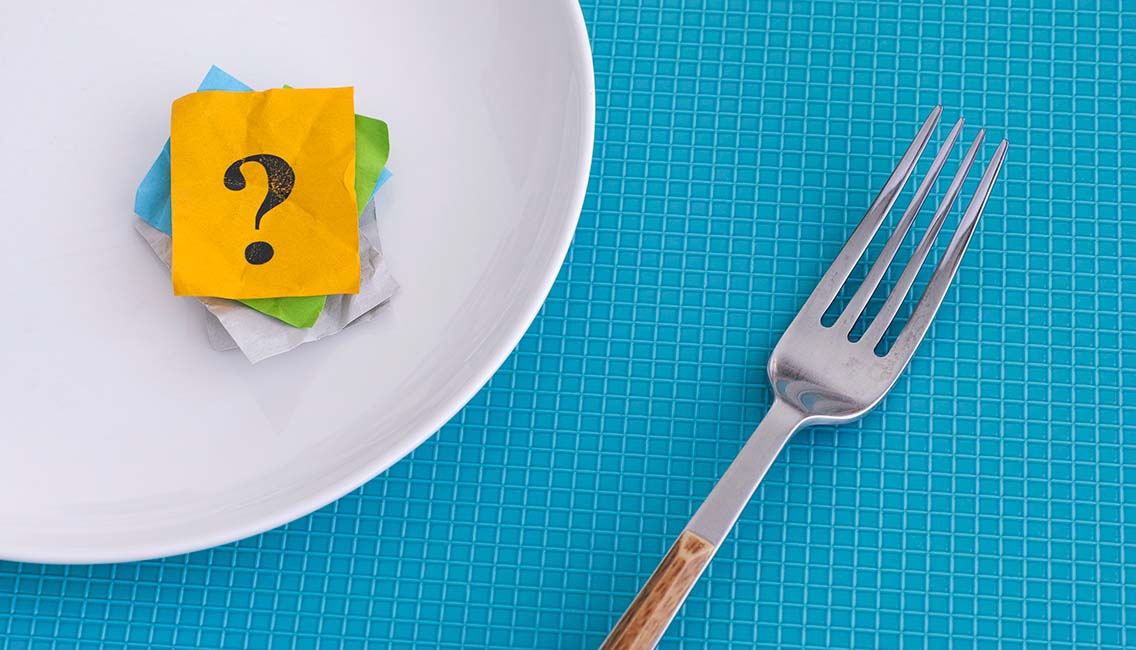 Question mark on an empty white plate with fork