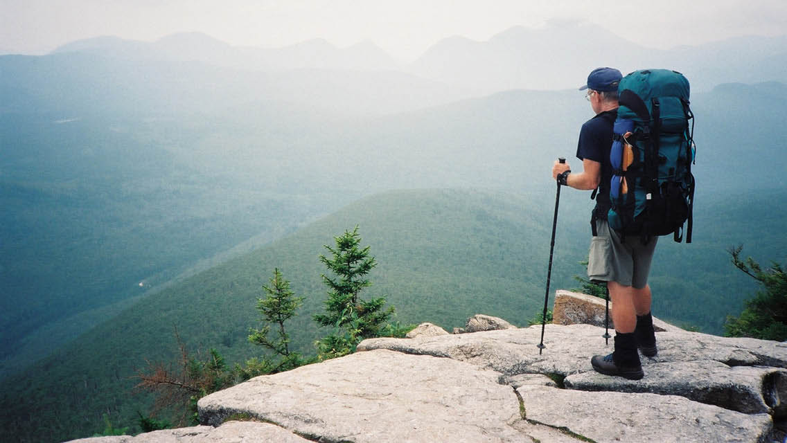 a man with a large backpack overlooks the Appalachian Mountains