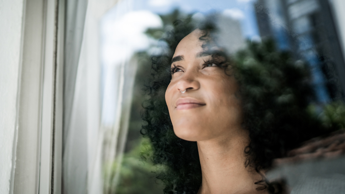 a woman looks out the window with a determined expression