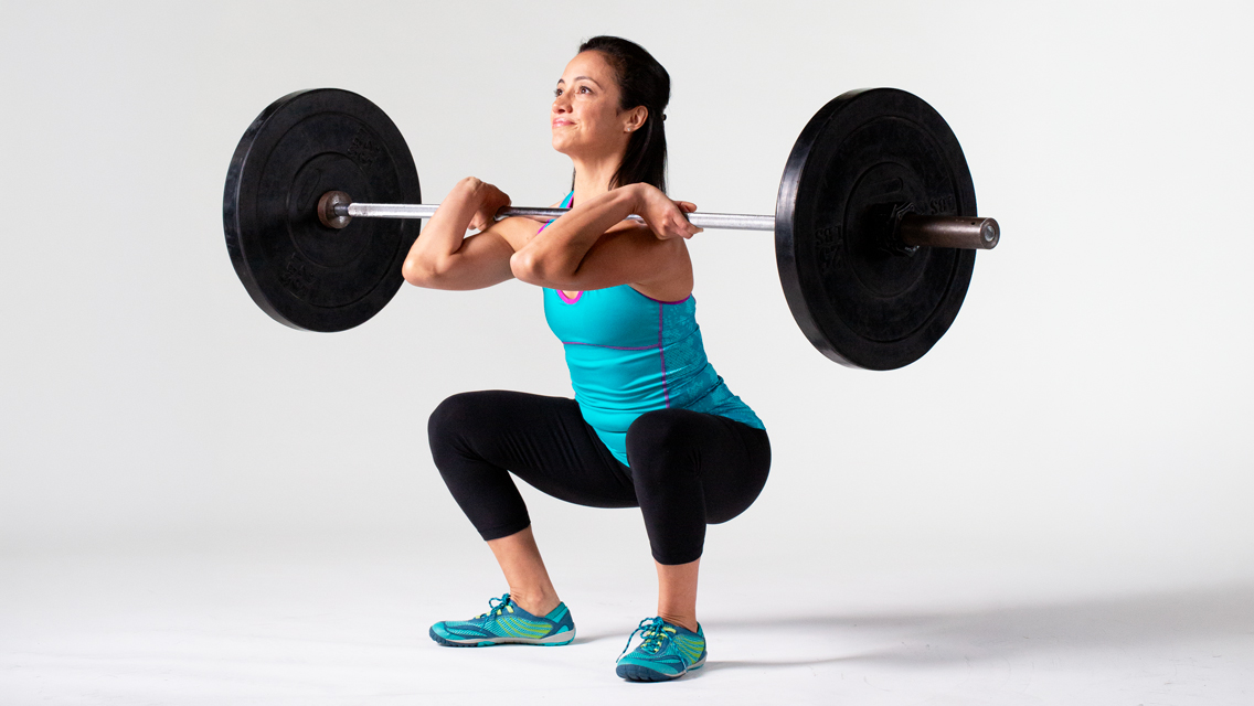 a woman holding a barbell front squat