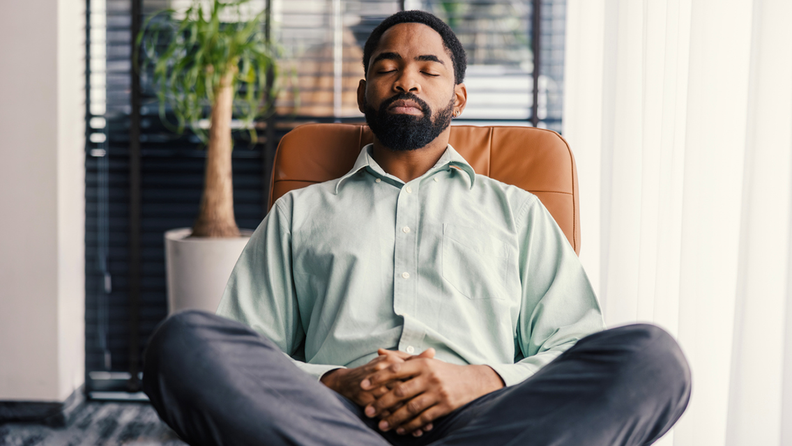 a man sits with his eyes closed thinking