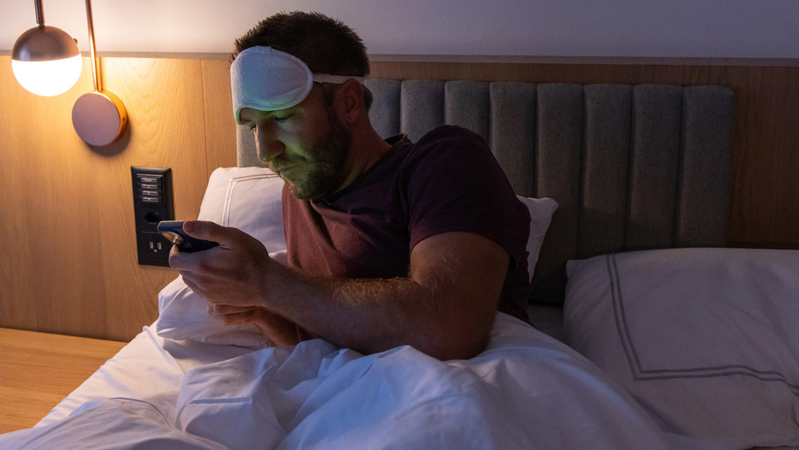 a man checks his phone before going to bed