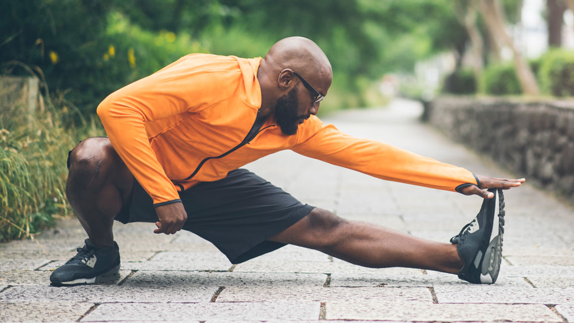 a fit, older african american performs a deep stretch