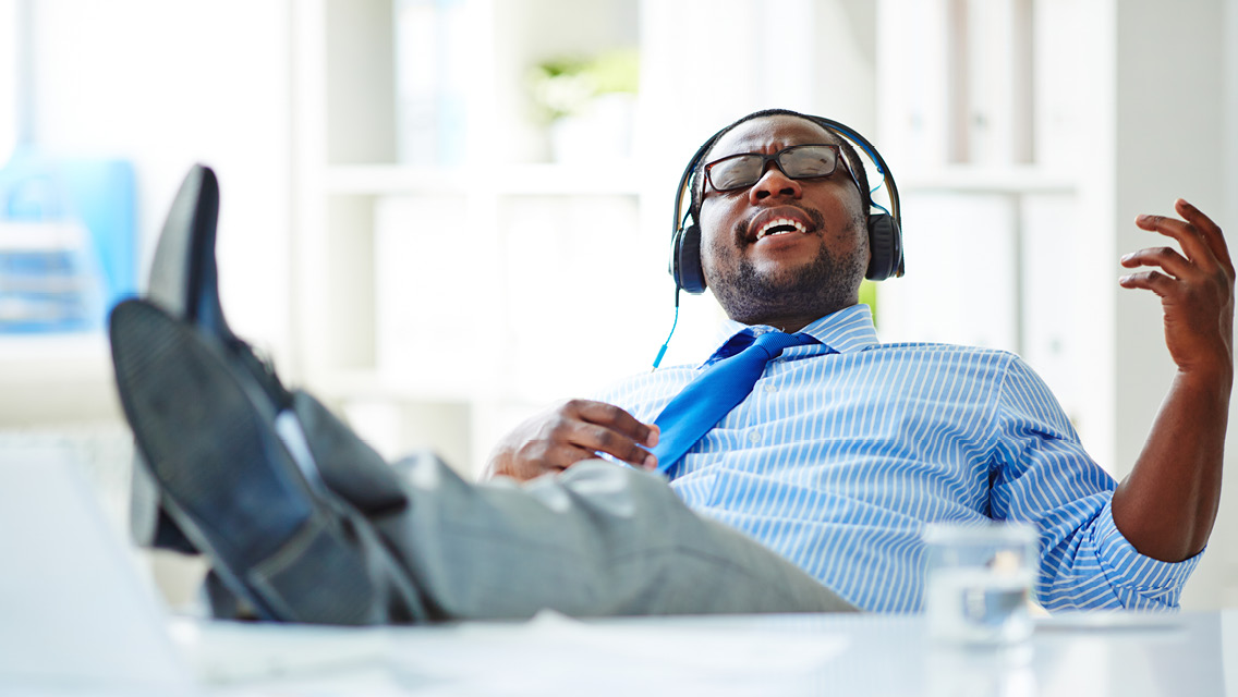 Businessman listening to music in headphones at office