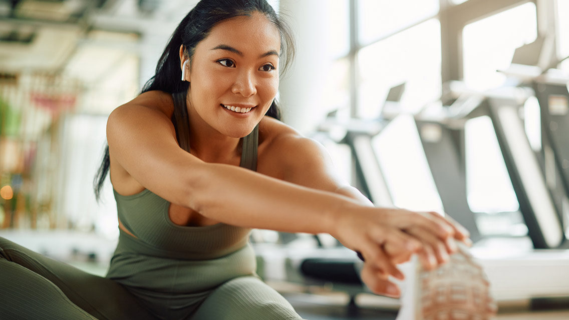 women at gym stretching between sets