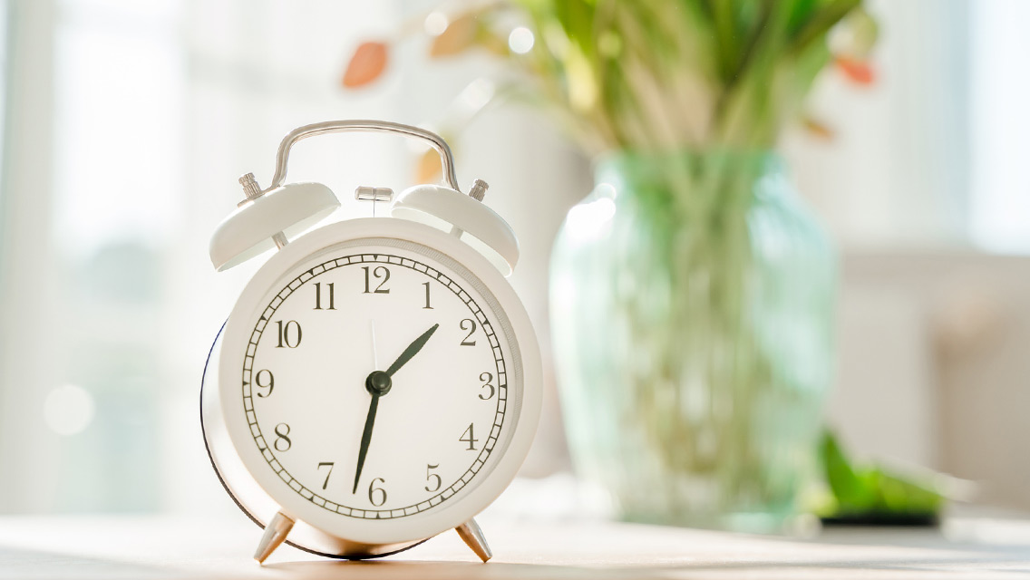 alarm clock with tulips behind it