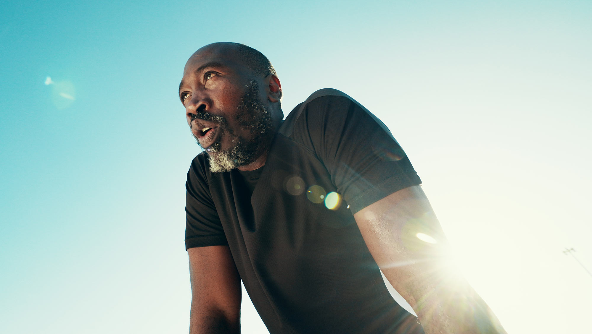 a mature male athlete rests during outdoor cardio exercise