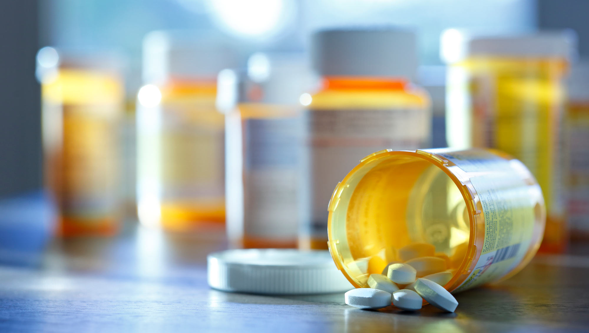 a variety of prescription medication bottles on a counter