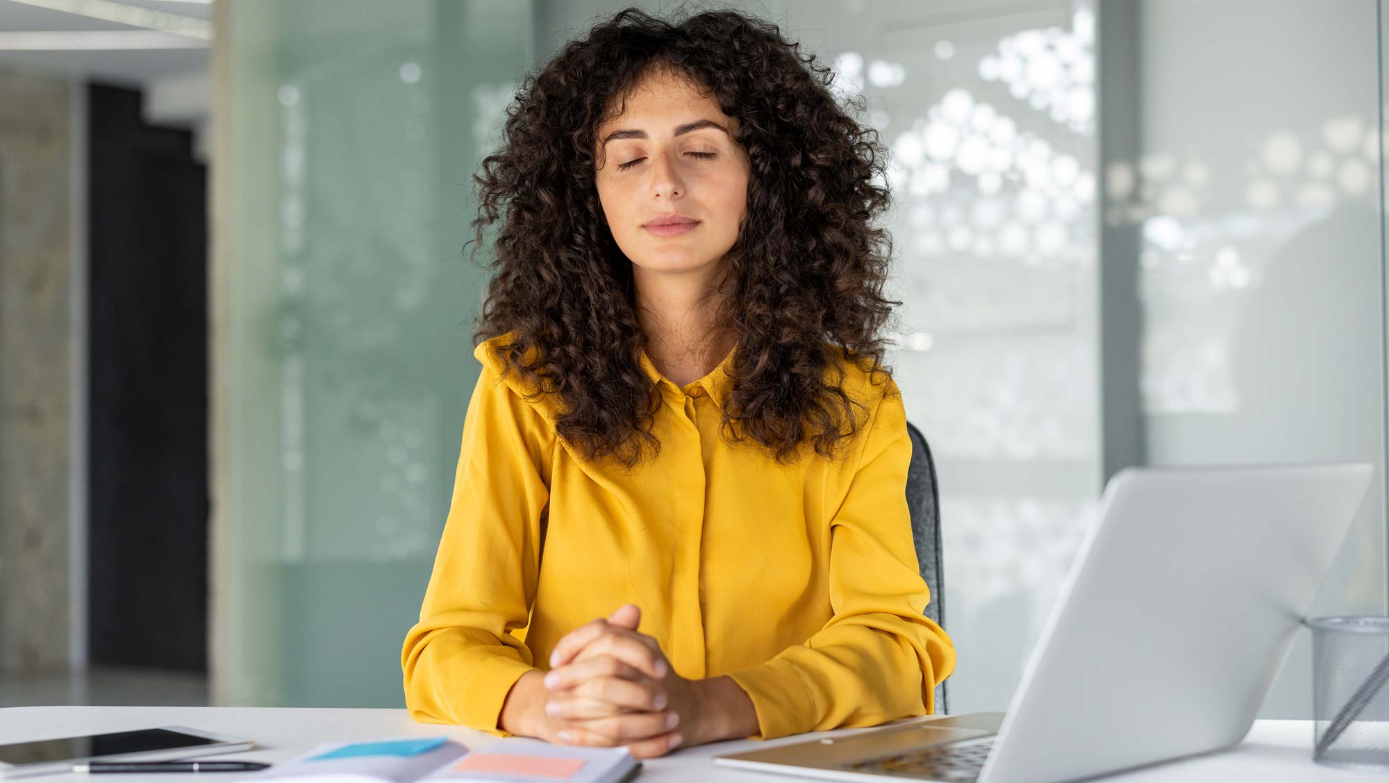 Businesswoman practicing mindfulness meditation at her desk