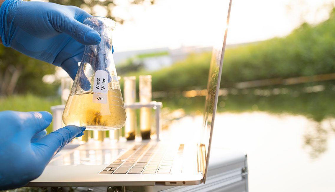 Environment engineer Collect samples of wastewater from industrial canals in test tube