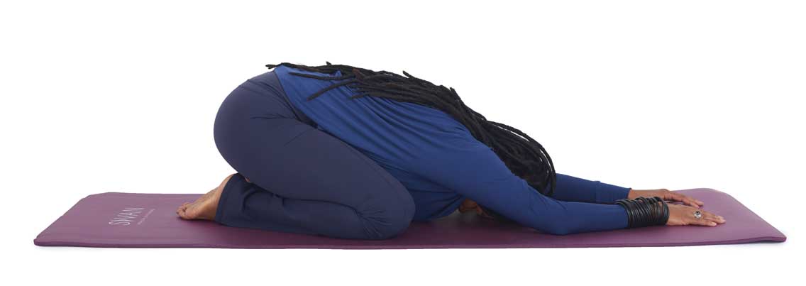 a woman holds childs pose