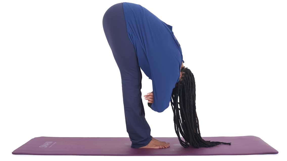 a woman holds a forward fold