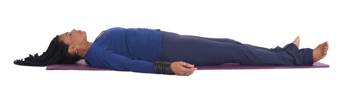 a woman lies in savasana