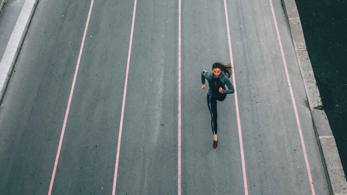 an overhead shot of a woman sprinting on a track
