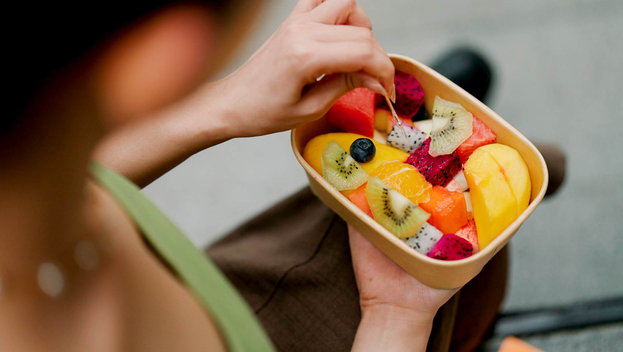 a woman eats fresh fruit