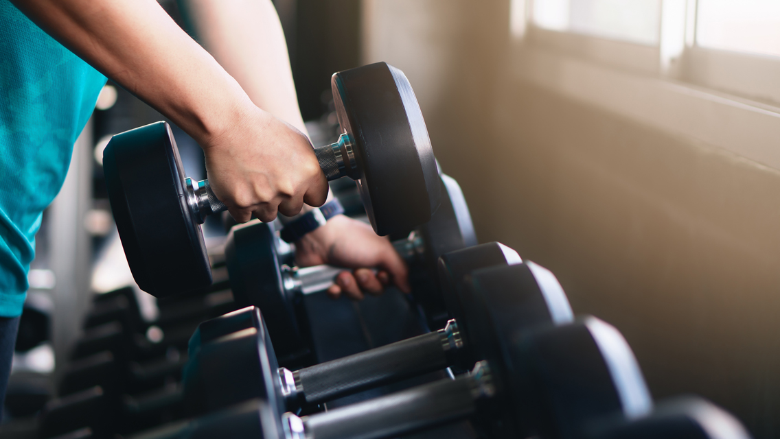 a person picks up a dumbbell