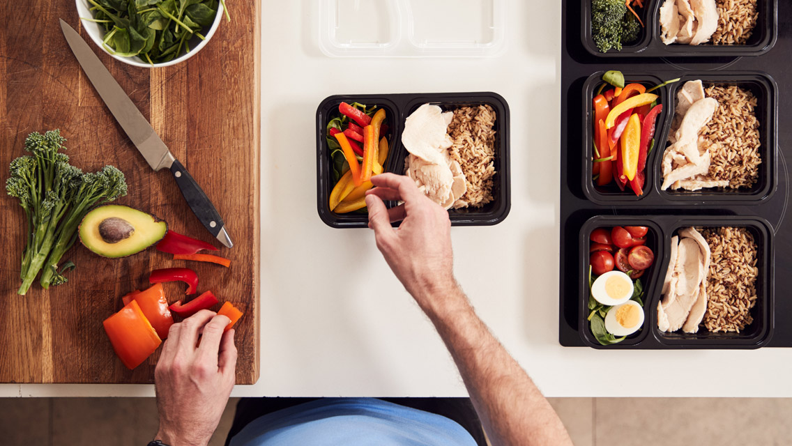 an overhead shot of a person packing high protein meals