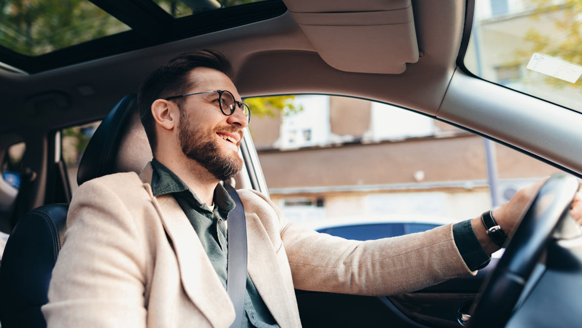 a man wearing causal business attire drives home