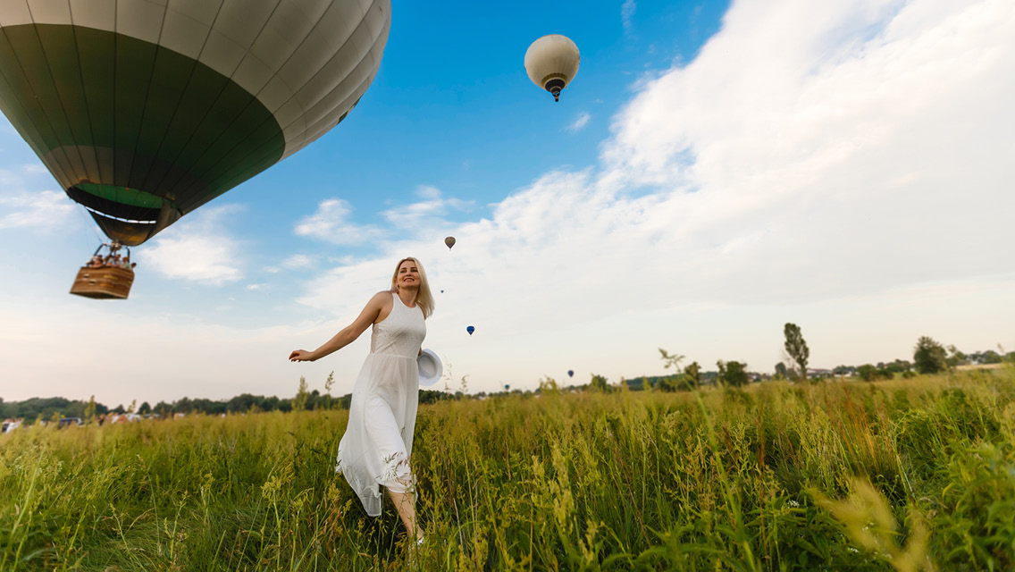 A woman in field of hot air balloons
