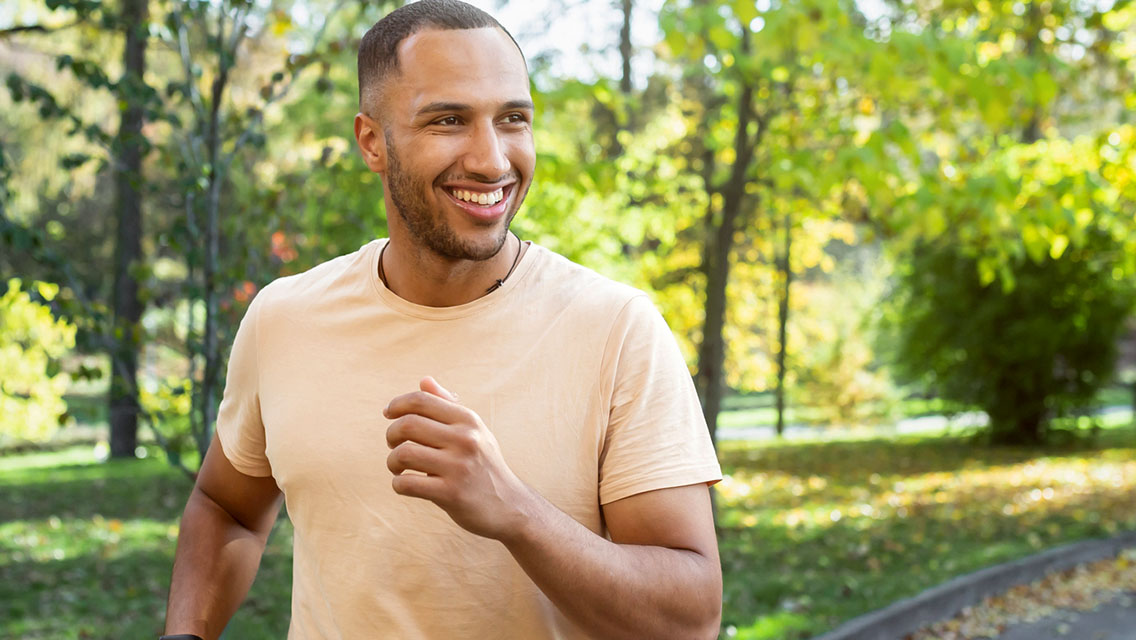 a man smiles while jogging