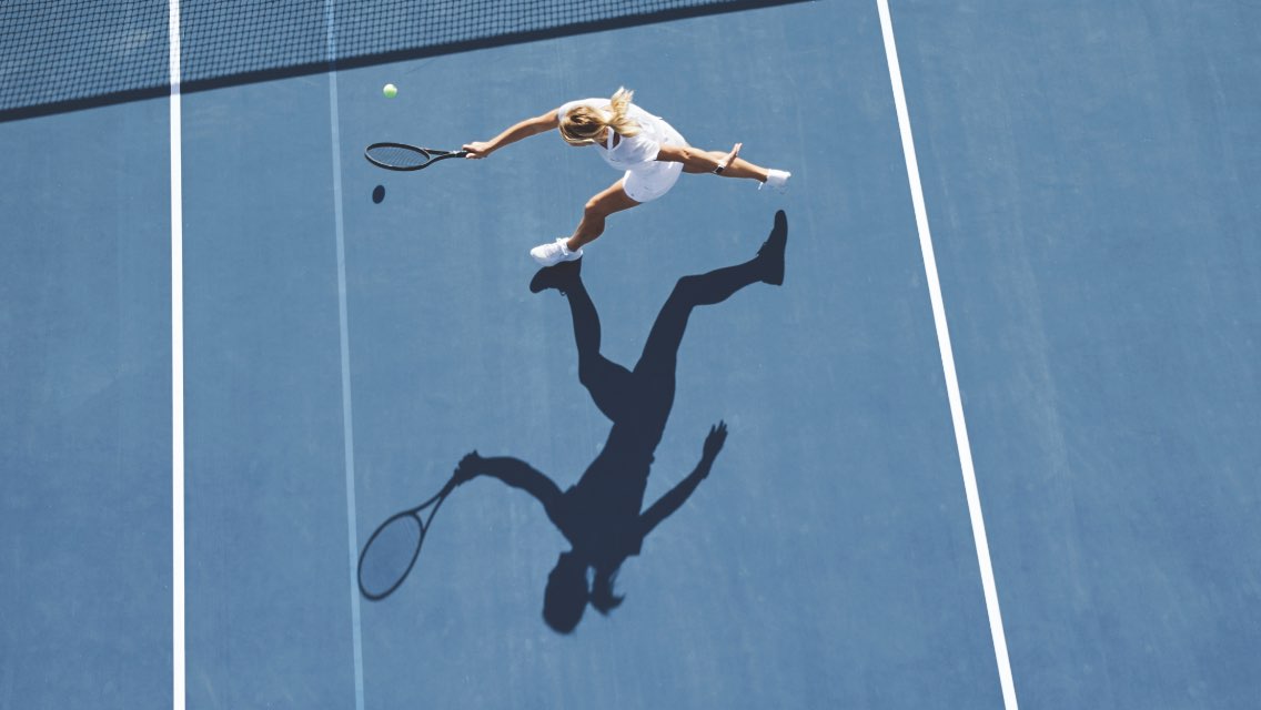 A woman playing tennis outdoors.