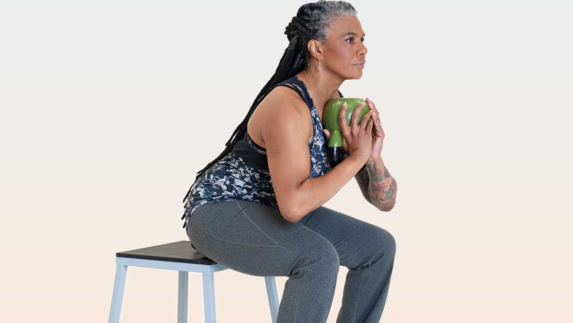 a woman performs a squat on a step