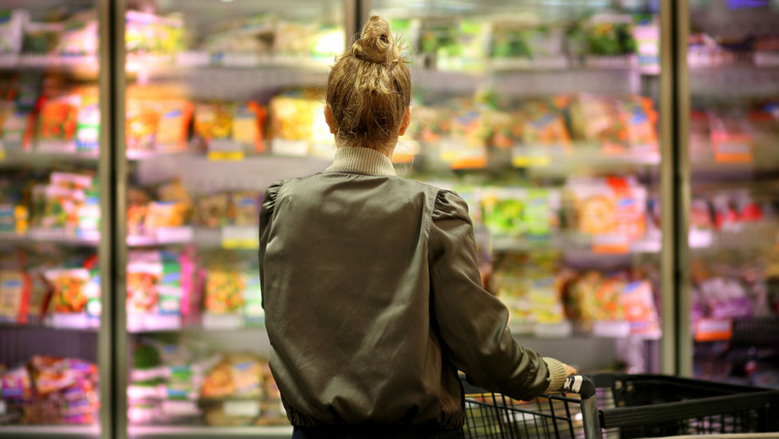 a woman looks at the frozen foods section