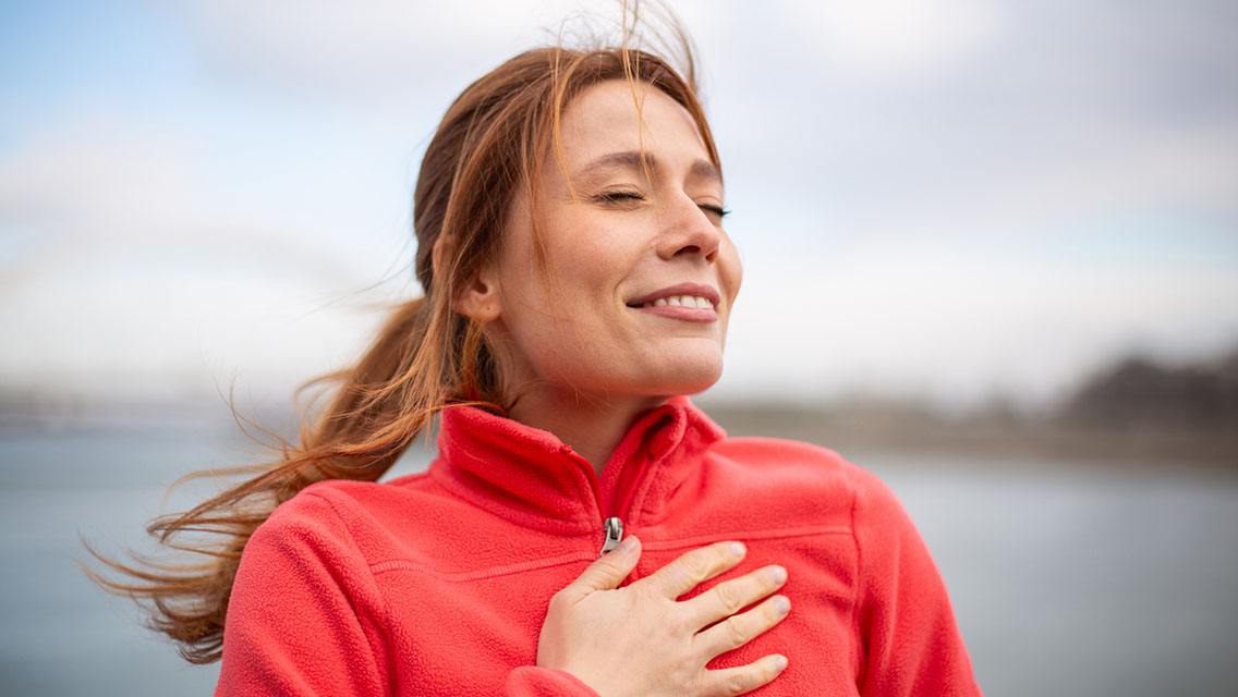 Woman breathing deeply and feeling gratitude in nature