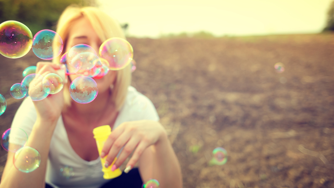 a woman blows bubbles