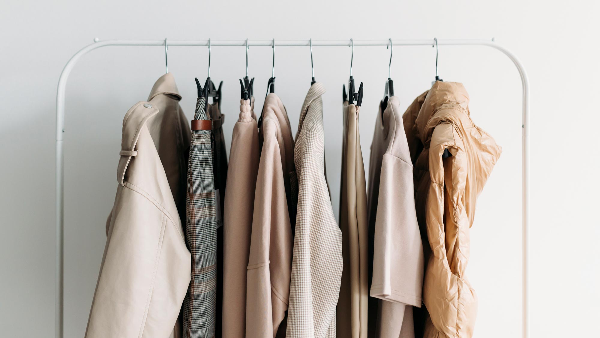Capsule clothes of beige coloron a rack