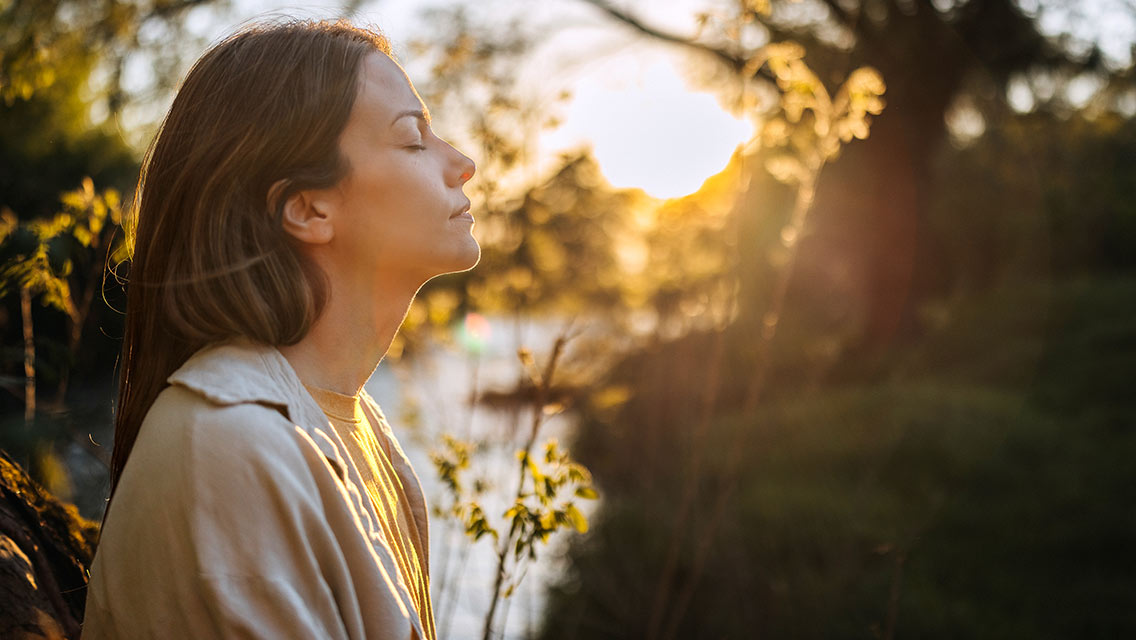 Woman sitting outside during sunrise