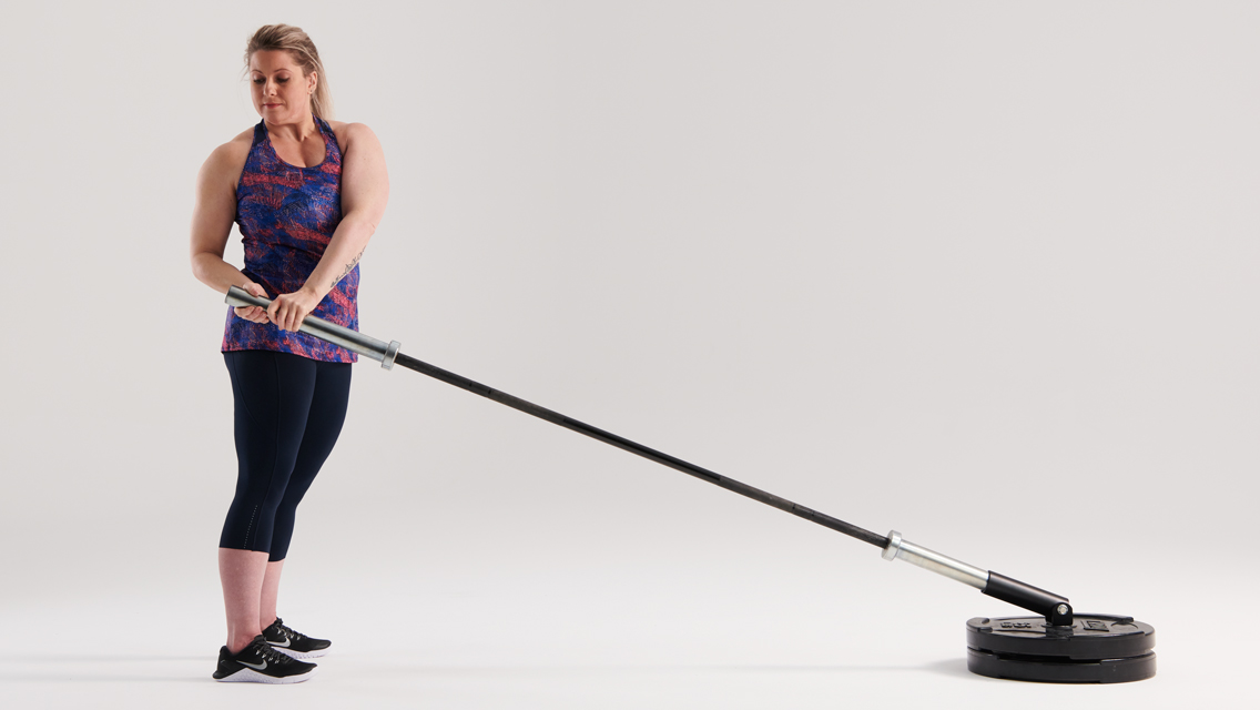 a woman performs an anti-rotation with an anchored barbell