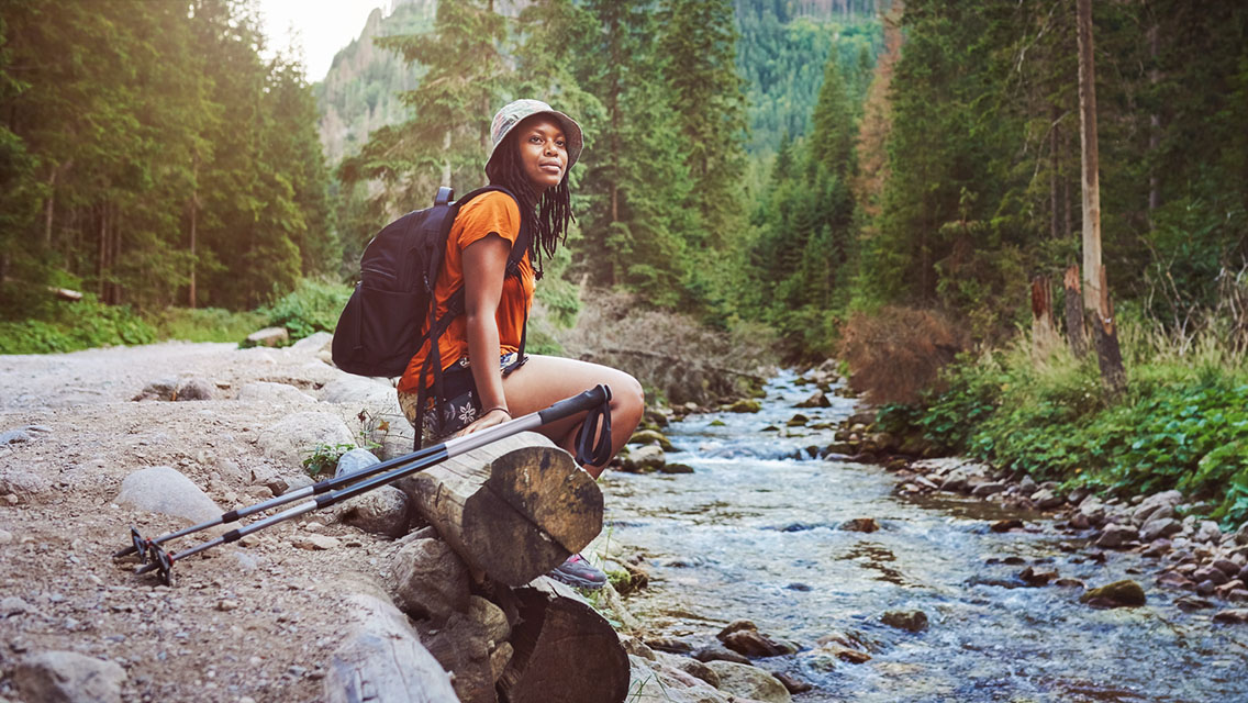 a woman hikes with trekking poles