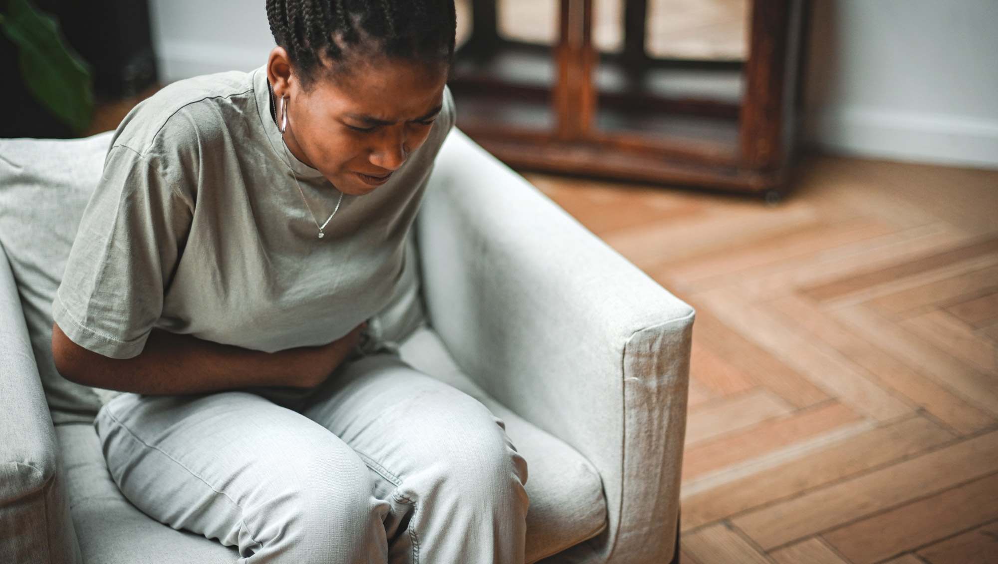 a woman grips her stomach in pain