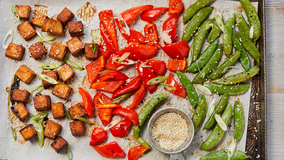 Tofu, red pepper and snap peas on a sheet pan.
